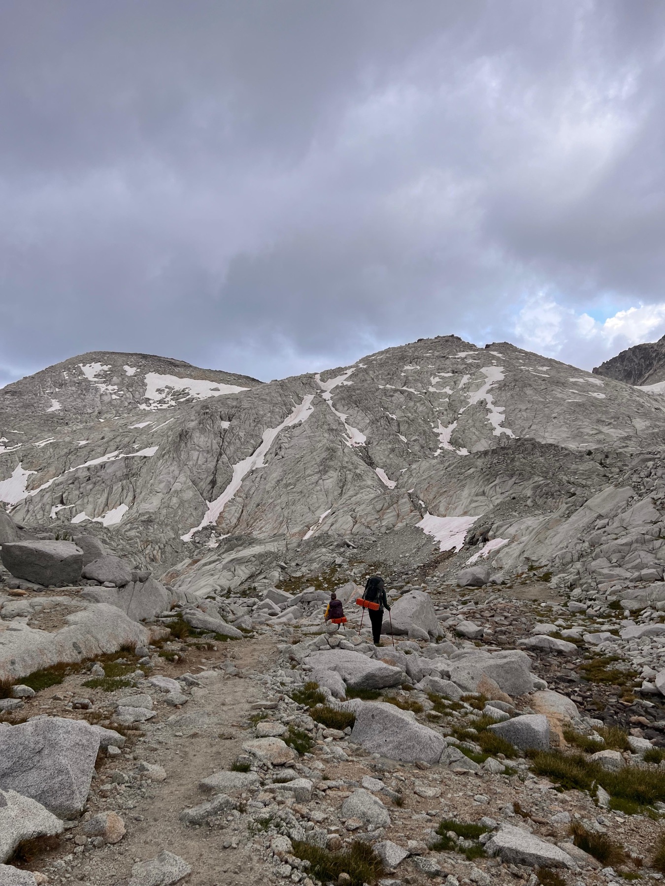 Hikers crossing the upper Enchantments under thunderclouds